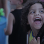A smiling kid holding balloons